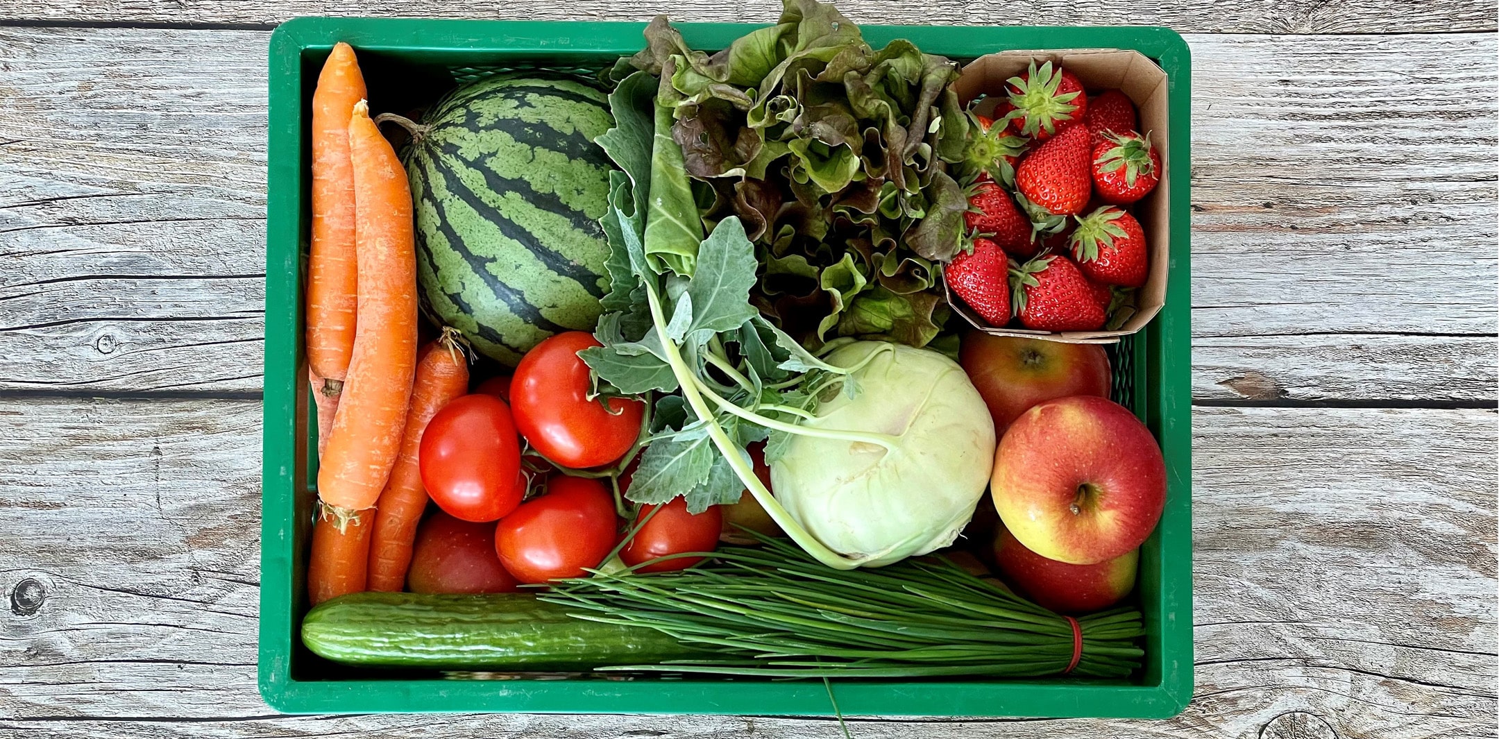 Biokiste gefüllt mit frischem Obst und Gemüse.