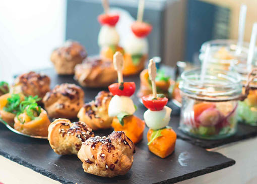 Verschiedene bunte Antipasti auf Schieferplatte und in Gläsern.