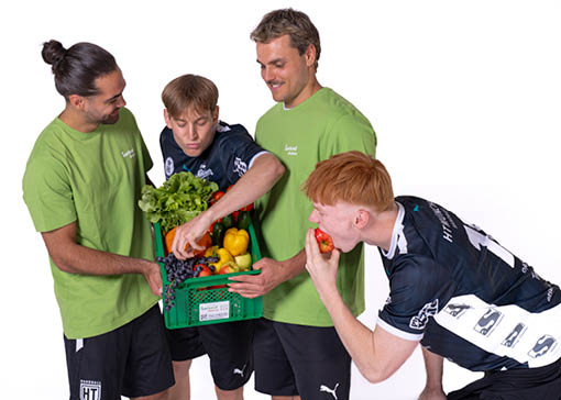 Vier Handballer mit einer mit Obst und Gemüse gefüllten Isarland Ökokiste. Bild © Walter Slavik