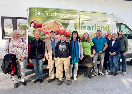 Gruppenbild vor einem Isarland Lieferwagen mit Kundinnen und Kunden sowie Geschäftsführerin Nicole Göpel und Mitarbeiter Torsten Gauer.