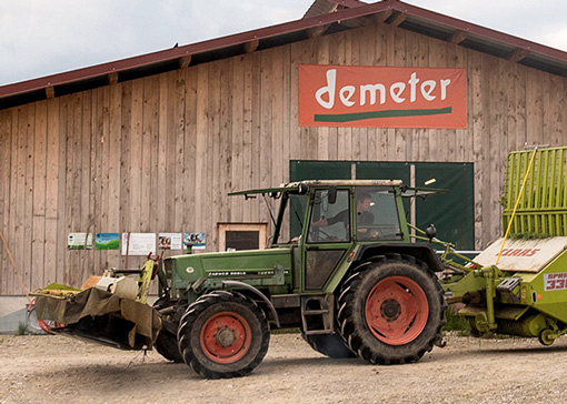 Eine Maschinenhalle, vor der ein Traktor steht.