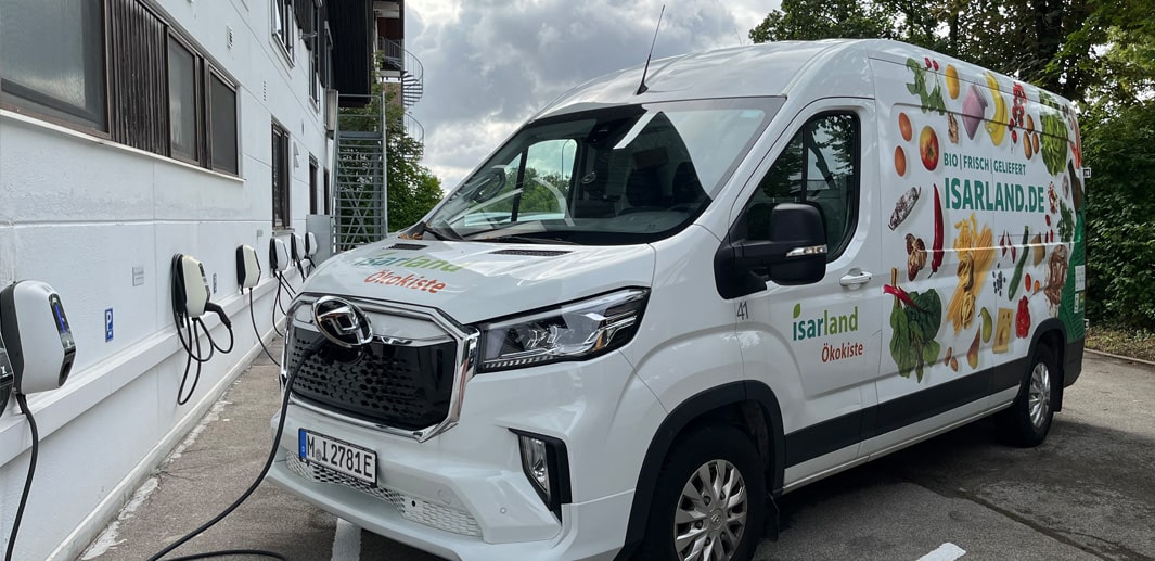 Isarland Ökokisten E-Lieferwagen lädt an der Wallbox.