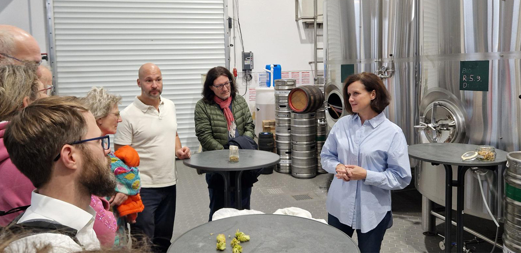 Marta Girg von der Haderner Bräu spricht mit Besucherinnen und Besuchern in den Räumlichkeiten der Brauerei.