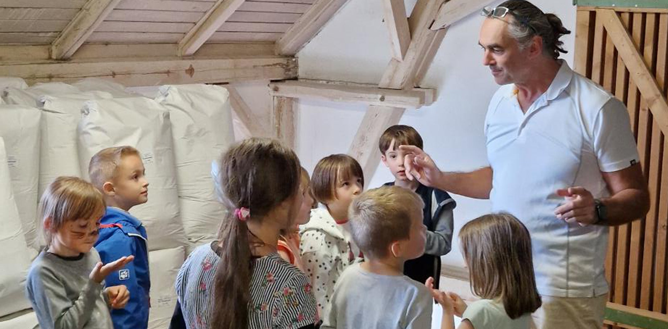 Müllermeister Löffl erzählt Kindern im Mehllager Wissenswertes aus dem Mühlenalltag.