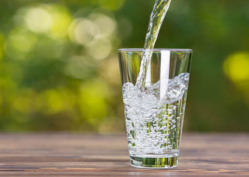 Ein Glas, in das Wasser fließt.